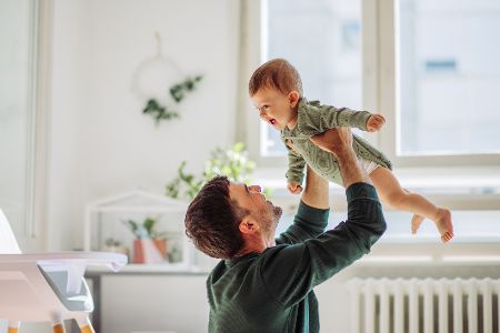 Vater wirbelt sein Kleinkind durch die Luft