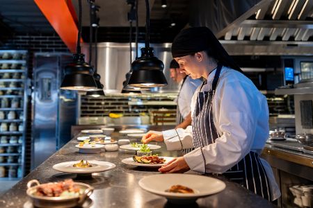 Köche in einer Restaurantküche garnieren Teller