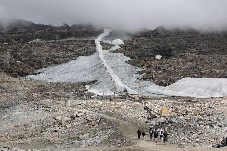 Ein schmales Schneeband: Menschen sind am Mölltaler Gletscher in Kärnten unterwegs.
