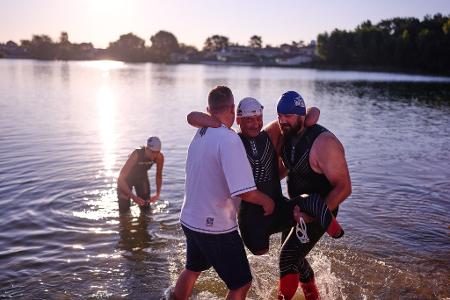 Dem ukrainischen Kriegsveteranen Oleksii Kozak wird bei einer Sportveranstaltung am Rande von Kiew geholfen, aus dem Wasser zu steigen.