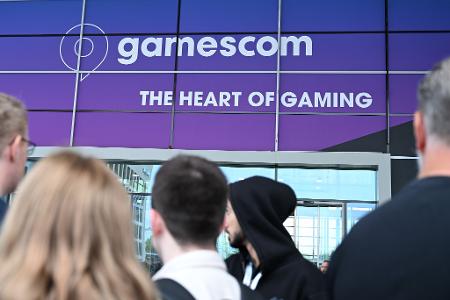 Sie können es kaum Abwarten: Besucherinnen und Besucher warten bei der Gamescom 2025 darauf, dass die Türen aufgehen und sie in die Messehallen strömen können. (Archivbild)