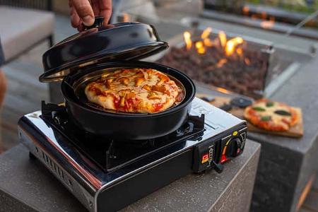 Omnia Stovetop Pizza Oven in Benutzung draußen beim Camping