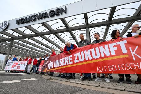 Vor der Betriebsversammlung von VW in Zwickau demonstrieren Beschäftigte am Werkstor.