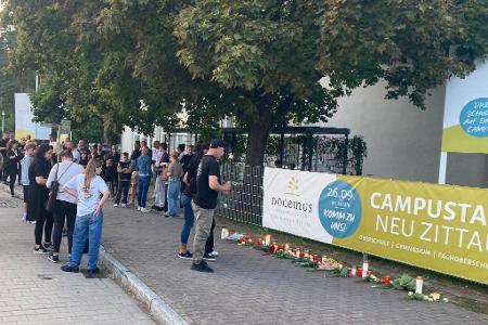 Menschen gedenken der zwei Toten in Neu Zittau. 