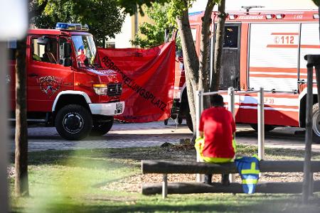 Ein Feuerwehrmann sitzt in der Nähe des Tatorts. 