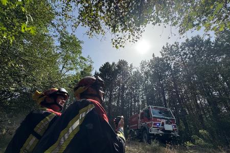 Einsatzkräfte am Boden geben Informationen an Löschhubschrauber weiter