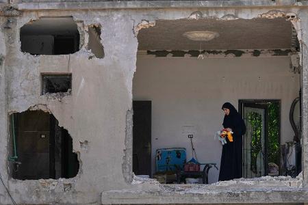 Eine Frau begutachtet ihr beschädigtes Haus an der Stelle einen Tag nach einem israelischen Luftangriff im Dorf Arab Salim im Südlibanon.
