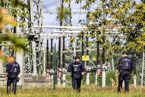 Einsatzkräfte der Polizei durchsuchten auch am Tag nach der Tat das Gelände um die Hochspannungsleitungen.