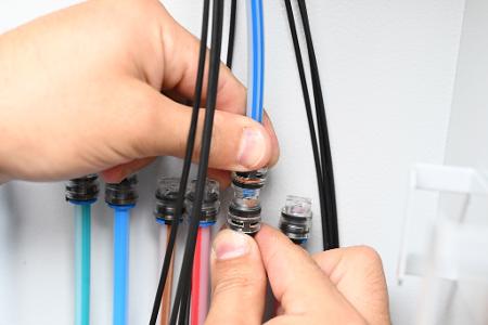 Ein Techniker verbindet Glasfaser-Kabel, um besonders schnelles Internet zu ermöglichen.