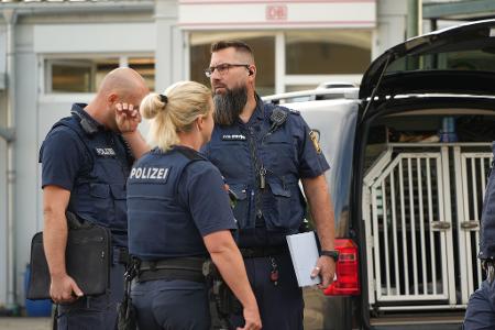 Einsatzkräfte der Polizei stehen in der Nähe des Bahnhofs.
