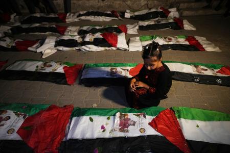 Ein Mädchen sitzt neben den Leichen von Palästinensern an, die aus den Trümmern von Häusern geborgen wurden, die während des Krieges zwischen Israel und der Hamas in Gaza Stadt zerstört worden waren.