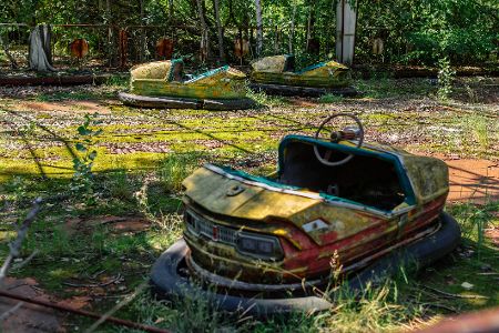 Verrottete Autoscooter auf einer überwucherten Bahn