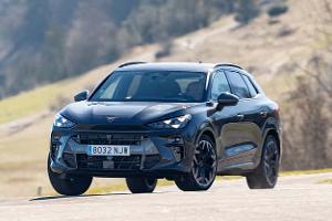 Der Cupra Terramar 2.0TSI 4Drive ist auf einer Landstraße in ländlicher Umgebung zu sehen. Das Fahrzeug fährt dynamisch auf den Betrachter zu, die Landschaft im Hintergrund ist leicht verschwommen.