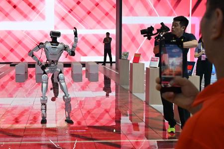 China: Besucher verfolgen auf der 26. Investitions- und Handelsmesse die Vorführung eines Roboters
