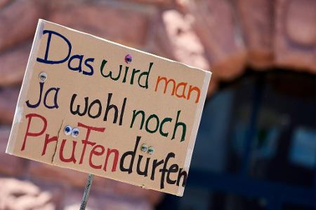 Ein Demonstrant hält ein Protest-Schild bei der Demonstration in Mainz.