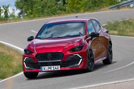 Renault Clio Full Hybrid E-Tech 160 auf Landstraße in Kurvenfahrt, rote Lackierung, moderne Kompaktklasse.