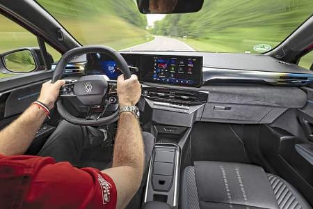 Innenraumaufnahme eines Renault Clio Full Hybrid E-Tech 160 während der Fahrt, Blick aus Fahrersicht auf Lenkrad, digitales Cockpit und Infotainment-Display.