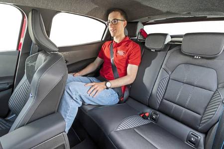 Innenraumaufnahme eines Renault Clio Full Hybrid E-Tech 160, Rücksitzbank mit Person.