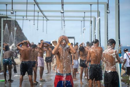 Migranten duschen in einer Anlage am Strand von El Trampolín in der spanischen Exklave Ceuta, wo zahlreiche provisorische Unterkünfte errichtet wurden.