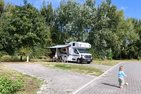 Stellplatz mit Ahorn Alkoven A690: Ausgefahrene Markise und spielendes Kind