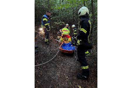 Feuerwehr und Rettungsdienst bereiten den Transport aus dem Wald vor.