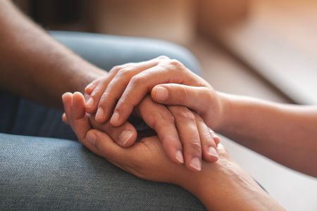 Ein Händepaar ergreift unterstützend ein weiteres