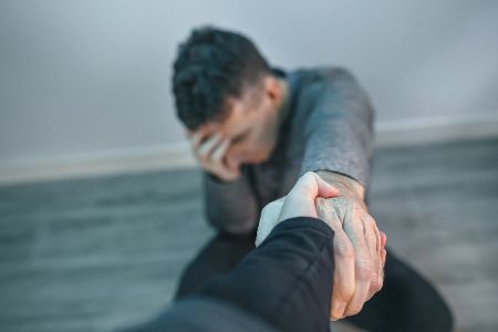 Verzweifeltem Mann wird die Hand gereicht