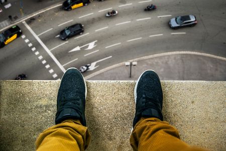 Füße stehen auf einem Absatz über einer Straße