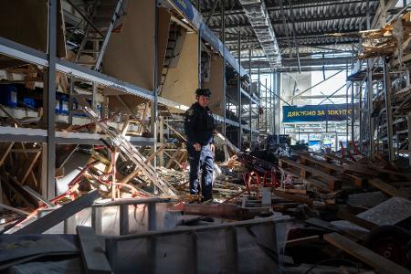 Charkiw: Ein Polizeibeamter steht in einem durch einen russischen Drohnenangriff beschädigten Geschäftsgebäude.
