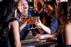 Junge Menschen auf einer Party stoßen mit Alkohol an