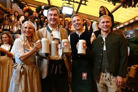 Karin Baumüller-Söder, Markus Söder (CSU), Ministerpräsident von Bayern, Dominik Krause (Bündnis 90/ Die Grünen), Oberbürgermeister von München, und sein Partner Sebastian Müller stoßen auf eine friedliche Wiesn an.
