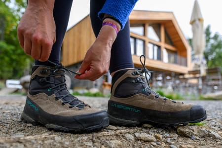 Eine Frau schnürt ihre Wanderschuhe. Deutschland gilt mit seinen vielfältigen Landschaften und Regionen als Wanderland. 