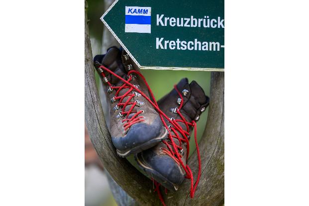 Wanderschuhe stehen in einem Wegweiser am Fuß des Fichtelbergs.