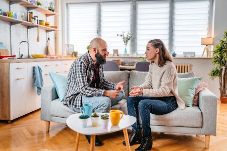 Pärchen sitzt auf dem Sofa und diskutiert