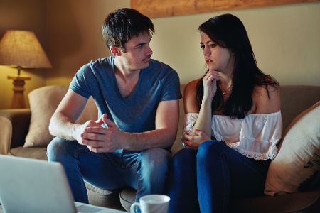 Pärchen sitzt zusammen auf dem Sofa und unterhält sich