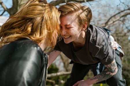 Weibliches Pärchen schaut sich im Park lächelnd an