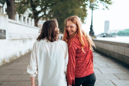 Weibliches Pärchen auf der Straße, von denen sich eine Frau umdreht