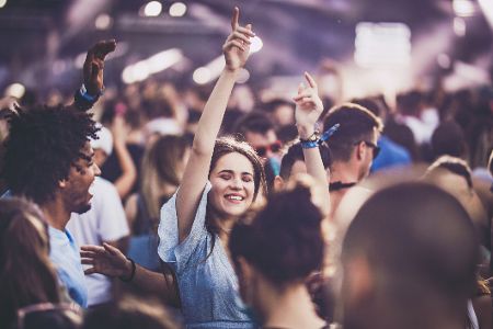 Junge Menschen verschiedener Ethnien tanzen auf einem Konzert