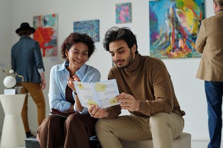 Pärchen sitzt im Museum und schaut sich ein Programm an