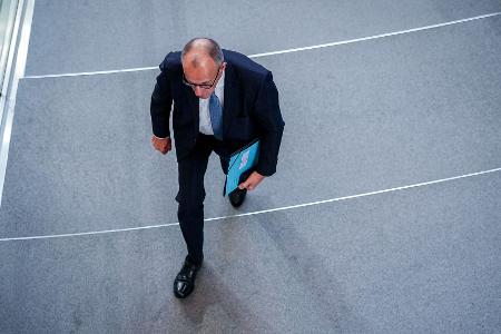 Berlin: Bundeskanzler Merz geht aus dem Bundestag 