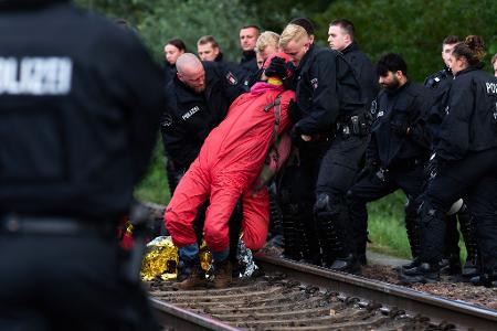 Polizisten räumen eine Gleisblockade im Hamburger Hafen, mit der Aktivisten gegen steigende Militärausgaben protestieren.