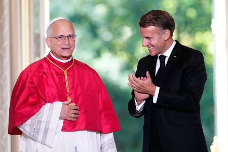Frankreichs Präsident Emmanuel Macron beklatscht den Gast aus dem Vatikan.