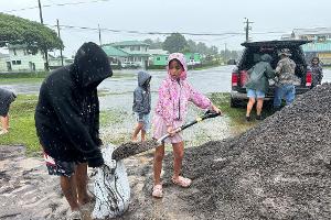 In Hawaii füllen Menschen Sandsäcke, um ihre Häuser vor den Auswirkungen von "Nolo" zu schützen.
