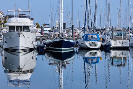 Motor- und Segelboote spiegeln sich in der Marina im Wasser. Teilweise sonnig und mit milden Temperaturen zeigt sich das Herbstwetter in Norddeutschland von seiner freundlichen Seite.