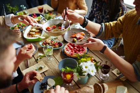 Menschen füllen sich Essen auf Teller