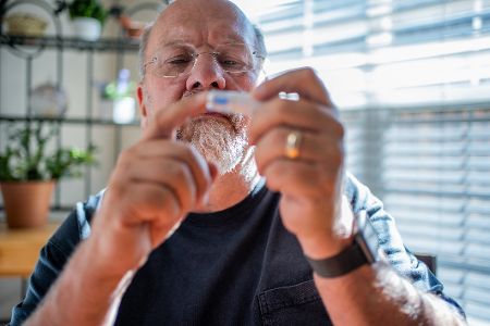 Mann misst seinen Blutzuckerspiegel