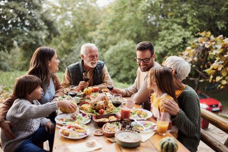 Familie im Garten an einem voll gedeckten Essenstisch