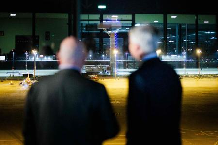 Stefen Bilger (r, CDU), Bundesminister für Verkehr, und Robert Crumbach (l, SPD), Minister für Infrastruktur und Landesplanung, blicken nach einem Pressestatement zum neuen Drohnendetektor am BER auf der Besucherterrasse des Flughafen "Willy Brandt" Berlin Brandenburg (BER) auf den Tower.