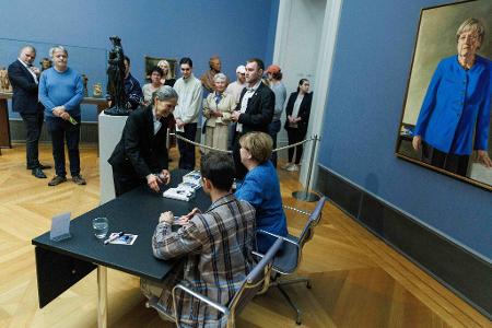 Im Bode-Museum signierte Merkel am Nachmittag Kunstpostkarten gemeinsam mit dem Maler ihres Porträts.