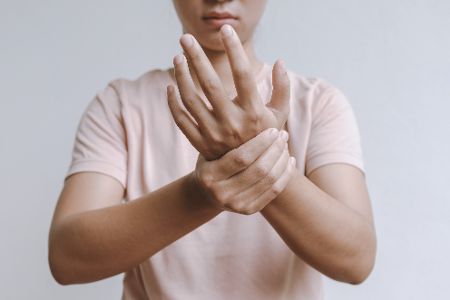 Person mit Lähmungserscheinungen in der Hand